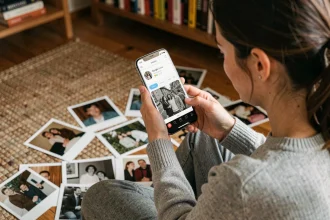 Femme utilisant Google Lens dans Google Photos pour numériser et identifier d'anciennes photos imprimées sur le sol de son salon